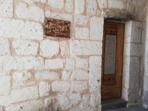 a brick wall with a wooden door on it at Pigeon Hotel Cappadocia in Uçhisar