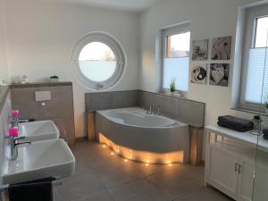 a bathroom with a tub and two sinks and a window at Urban Apartement-Boardinghouse Wadersloh in Wadersloh +24 photos
