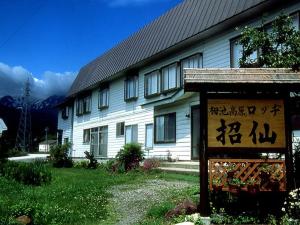 un edificio blanco con un cartel delante en Lodge Shosen, en Otari