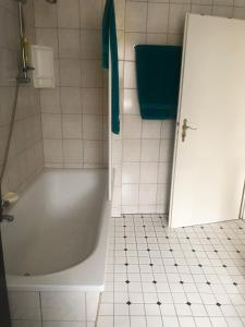 baño con bañera blanca y toalla azul en Ferienwohnung in der schönen Rhön en Stadtlengsfeld