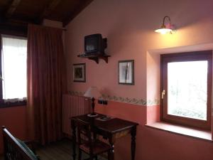 a room with a table and a television and a window at Casa del Contrabbandiere in Pozzolengo