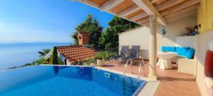 a house with a swimming pool with a view of the ocean at Apartments Villa Krasa in Lovran