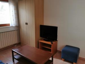 salon z telewizorem, stołem i niebieskim krzesłem w obiekcie Apartma Jowz w mieście Bovec