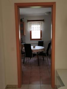 jadalnia ze stołem i krzesłami oraz oknem w obiekcie Apartma Jowz w mieście Bovec