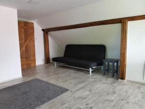 un sofá negro sentado en la esquina de una habitación en Apartmány Svatá en Svatá