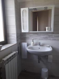 W białej łazience znajduje się umywalka i lustro. w obiekcie Malpensa Bed & Breakfast w mieście Case Nuove