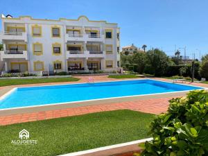 una villa con piscina frente a un edificio en Água à Vista - Apto com 2 quartos e Piscina, en Ericeira