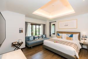 a bedroom with a large bed and a couch at NH Collection Samui Peace Resort in Bophut