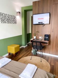 a hotel room with a desk and a tv on a wall at North-Hotel in Hamburg