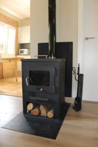 a black stove with logs in a living room at Vila Graugés in Ripoll