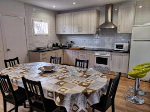 een keuken met een tafel met stoelen en een koelkast bij Villa Elena in Salou