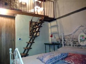 1 dormitorio con escalera de caracol junto a la cama en Casa in campagna per vacanze in Umbria con piscina, en Vicolo Rancolfo