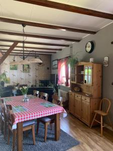a dining room with a table and a kitchen at B&B De Kaagse Koe in Huigsloot