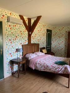 1 dormitorio con cama y papel pintado con motivos florales en B&B De Kaagse Koe, en Huigsloot