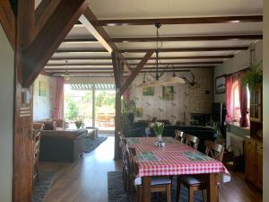 a dining room with a table and a living room at B&B De Kaagse Koe in Huigsloot
