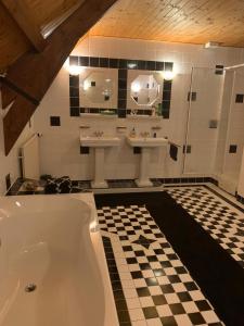 a bathroom with two sinks and a bath tub at B&B De Kaagse Koe in Huigsloot