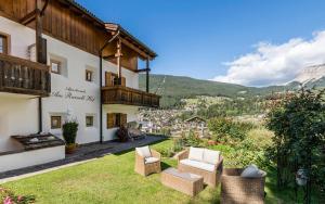 a house with a yard with chairs and a balcony at Am Rainell Hof in Ortisei