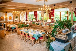 jadalnia ze stołami, krzesłami i oknami w obiekcie Örglwirt Ferienwelt - Hotel Post Örglwirt w mieście Mariapfarr