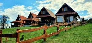 une maison sur une colline avec une clôture devant elle dans l'établissement Lodge Nagramak, à Sekulić 