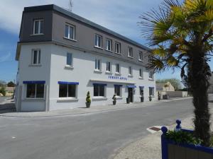 a large white building with a black roof at Hotel Jersey in Barneville-Carteret