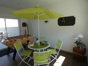 una stanza con tavolo e tavolo da biliardo con ombrellone di Hotel Jersey a Barneville-Carteret