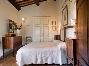 um quarto com uma cama branca e uma cómoda em Sirena em Montefollonico