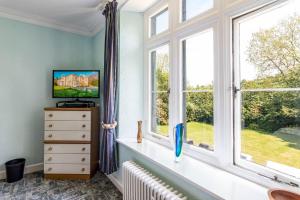 a room with windows and a radiator and a dresser at Ffarm Country House in Abergele