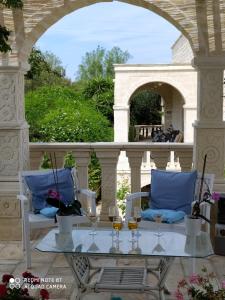 a patio with two chairs and a glass table at B&B Tenuta Martinelli in Monopoli