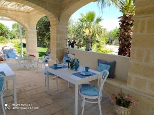 a patio with a white table and chairs and a window at B&B Tenuta Martinelli in Monopoli