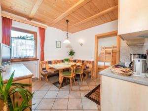 - une cuisine et une salle à manger avec une table et des chaises dans l'établissement Ciasa Raut, à La Valle