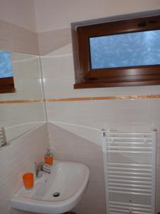 ein Bad mit einem Waschbecken und einem Fenster in der Unterkunft Apartmány Podkovička in Pavčina Lehota