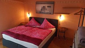 a bedroom with a large bed with red sheets and pillows at Amy's Apartment, relax and enjoy in Bonndorf im Schwarzwald