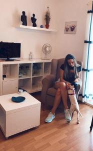 eine Frau, die mit einem Hund auf einem Stuhl sitzt in der Unterkunft Ca la Nuri Pis 2 con Vistas al Mar in Llança