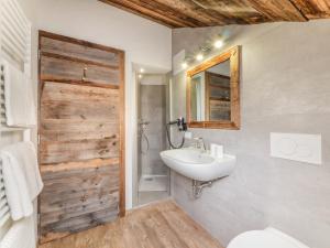 a bathroom with a sink and a toilet and a mirror at Ciasa Raut in La Valle