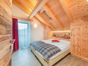 1 dormitorio con 1 cama en una habitación con techos de madera en Ciasa Raut, en La Valle