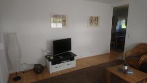 a living room with a flat screen tv on a white wall at Nordsee-Brise in Dornumersiel