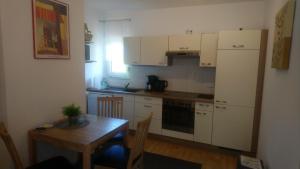 a small kitchen with a table and a refrigerator at Nordsee-Brise in Dornumersiel