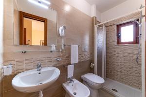 a bathroom with a sink and a toilet and a mirror at Il Nocchiero City Hotel in Soverato Marina