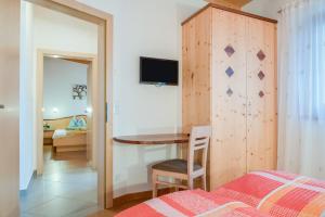 een slaapkamer met een tafel met een stoel en een bed bij Hofschenke Pfeiftal - Bergwiese in San Martino