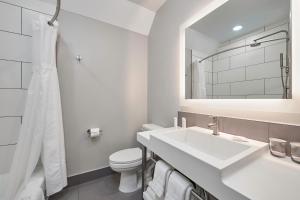 a white bathroom with a sink and a toilet at Radisson Hotel El Paso Airport in El Paso