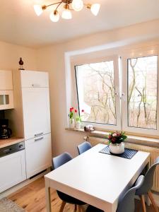 een keuken met een witte tafel en een aantal stoelen bij Ferienwohnung Ostseetraum in Rostock