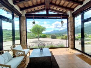 a living room with a large window with a view at Masia d'Amer - Complex rural amb encant in Amer