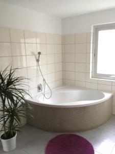 a bath tub in a bathroom with a plant at Ferienwohnung Edelweiß - Haus Martin in Bischofswiesen