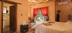 a bedroom with a bed and a large window at Dar Imlil in Imlil