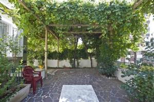 a pergola with a red chair and a bench at Bed and breakfast Grim in Trieste