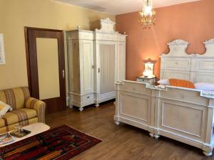 sypialnia z białymi meblami, łóżkiem i kanapą w obiekcie Appartamenti La Menaresta w mieście Magreglio