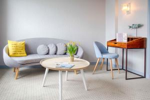 a living room with a couch and a table at Hotêl & Spa Du Parc Fétan in Larmor-Baden