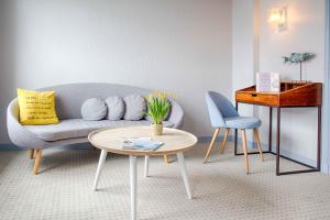 uma sala de estar com um sofá e uma mesa em Hotêl & Spa Du Parc Fétan em Larmor-Baden