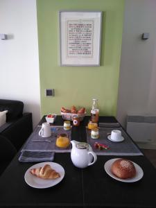 a table with a black table cloth with breakfast foods on it at APPART AIX MAZARIN in Aix-en-Provence