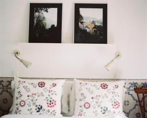 um quarto com três fotografias por cima de uma cama com almofadas em The Five House em Sintra